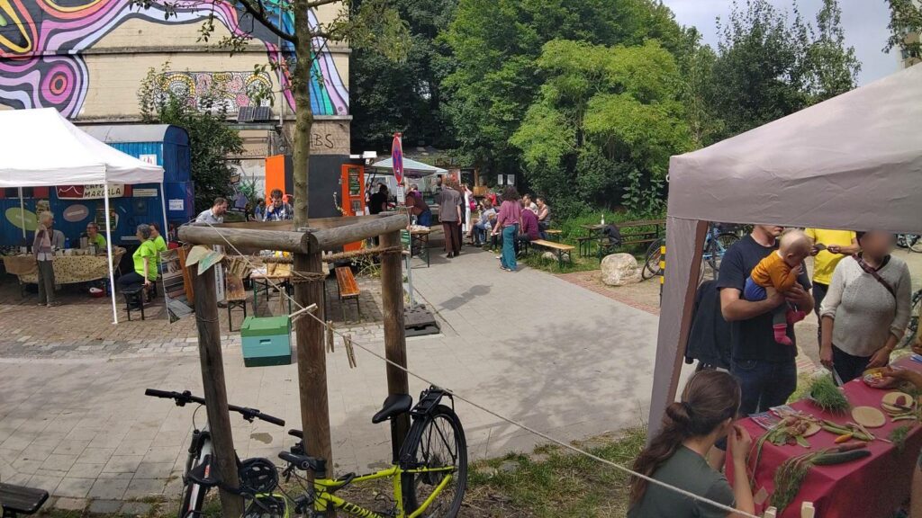 Blick auf den Bunker in der Schomburgstraße. Rechts ist ein Teil des SoLawi Stands zu sehen. Links Teile vom Sommerfest.